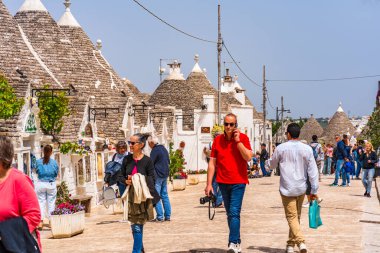 ALBEROBELLO, İtalya - 16 Mayıs 2024: İtalya 'nın Puglia bölgesindeki küçük bir İtalyan kasabası olan Alberobello' da turist gezisi. Alberobello 'nun tarihi merkezi UNESCO tarafından dünya mirası olarak ilan edildi.