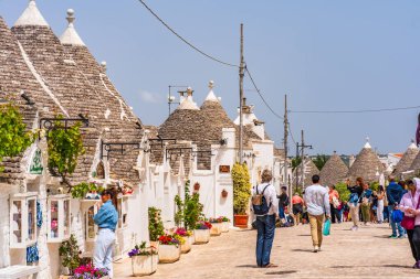 ALBEROBELLO, İtalya - 16 Mayıs 2024: İtalya 'nın Puglia bölgesindeki küçük bir İtalyan kasabası olan Alberobello' da turist gezisi. Alberobello 'nun tarihi merkezi UNESCO tarafından dünya mirası olarak ilan edildi.
