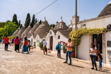 ALBEROBELLO, İtalya - 16 Mayıs 2024: İtalya 'nın Puglia bölgesindeki küçük bir İtalyan kasabası olan Alberobello' da turist gezisi. Alberobello 'nun tarihi merkezi UNESCO tarafından dünya mirası olarak ilan edildi.