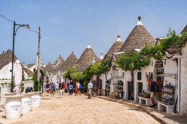 ALBEROBELLO, İtalya - 16 Mayıs 2024: İtalya 'nın Puglia bölgesindeki küçük bir İtalyan kasabası olan Alberobello' da turist gezisi. Alberobello 'nun tarihi merkezi UNESCO tarafından dünya mirası olarak ilan edildi.