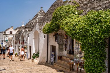 ALBEROBELLO, İtalya - 16 Mayıs 2024: İtalya 'nın Puglia bölgesindeki küçük bir İtalyan kasabası olan Alberobello' da turist gezisi. Alberobello 'nun tarihi merkezi UNESCO tarafından dünya mirası olarak ilan edildi.