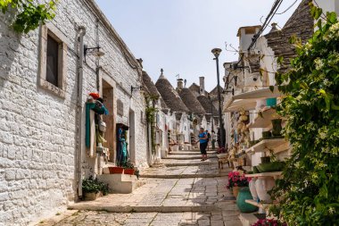 ALBEROBELLO, İtalya - 16 Mayıs 2024: İtalya 'nın Puglia bölgesindeki küçük bir İtalyan kasabası olan Alberobello' da turist gezisi. Alberobello 'nun tarihi merkezi UNESCO tarafından dünya mirası olarak ilan edildi.