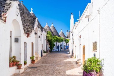 ALBEROBELLO, İtalya - 17 Mayıs 2024: Alberobello Puglia bölgesinde eski kuru taş trulli evleriyle ünlü küçük bir kasabadır. Alberobello 'nun tarihi merkezi UNESCO tarafından dünya mirası olarak ilan edildi.