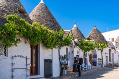 ALBEROBELLO, İtalya - 17 Mayıs 2024: İtalya 'nın Puglia bölgesindeki küçük bir İtalyan kasabası olan Alberobello' da turist gezisi. Alberobello 'nun tarihi merkezi UNESCO tarafından dünya mirası olarak ilan edildi.