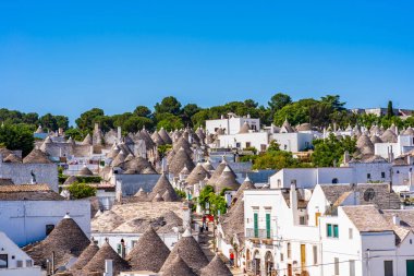 ALBEROBELLO, İtalya - 17 Mayıs 2024: Alberobello 'da konik çatıları olan ünlü eski kuru taş trulli evleri görmek. Alberobello 'nun tarihi merkezi UNESCO tarafından dünya mirası olarak ilan edildi..