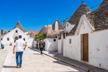 ALBEROBELLO, İtalya - 17 Mayıs 2024: Alberobello Puglia bölgesinde eski kuru taş trulli evleriyle ünlü küçük bir kasabadır. Alberobello 'nun tarihi merkezi UNESCO tarafından dünya mirası olarak ilan edildi.