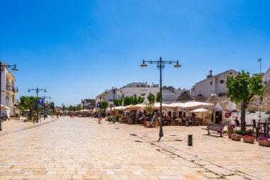 ALBEROBELLO, İtalya - 17 Mayıs 2024: İtalya 'nın Puglia bölgesindeki küçük bir İtalyan kasabası olan Alberobello' da turist gezisi. Alberobello 'nun tarihi merkezi UNESCO tarafından dünya mirası olarak ilan edildi.