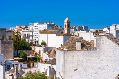 ALBEROBELLO, İtalya - 17 Mayıs 2024: Güney İtalya 'nın Puglia bölgesinde küçük bir İtalyan kasabası olan Alberobello' nun manzarası. Alberobello 'nun tarihi merkezi UNESCO tarafından dünya mirası olarak ilan edildi..