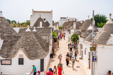 ALBEROBELLO, İtalya - 18 Mayıs 2024: İtalya 'nın Puglia bölgesindeki küçük bir İtalyan kasabası olan Alberobello' da turist gezisi. Alberobello 'nun tarihi merkezi UNESCO tarafından dünya mirası olarak ilan edildi.