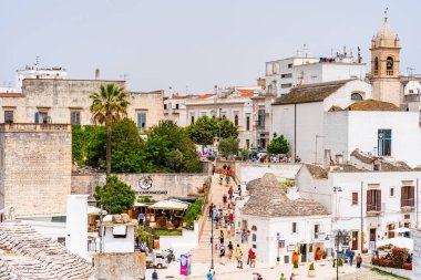 ALBEROBELLO, İtalya - 18 Mayıs 2024: İtalya 'nın Puglia bölgesindeki küçük bir İtalyan kasabası olan Alberobello' da turist gezisi. Alberobello 'nun tarihi merkezi UNESCO tarafından dünya mirası olarak ilan edildi.