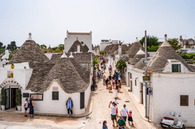ALBEROBELLO, İtalya - 18 Mayıs 2024: İtalya 'nın Puglia bölgesindeki küçük bir İtalyan kasabası olan Alberobello' da turist gezisi. Alberobello 'nun tarihi merkezi UNESCO tarafından dünya mirası olarak ilan edildi.