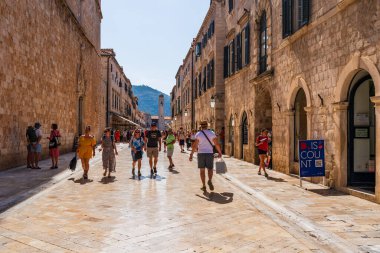 DUBROVNIK, CROATIA - 24 Haziran 2024: Tatilciler, ortaçağ duvarlarıyla çevrili ve Eski Liman manzaralı Hırvat kenti Dubrovnik 'te yaz tatilinin keyfini çıkarıyorlar
