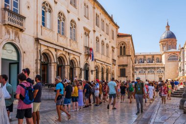 DUBROVNIK, CROATIA - 24 Haziran 2024: Tatilciler, ortaçağ duvarlarıyla çevrili ve Eski Liman manzaralı Hırvat kenti Dubrovnik 'te yaz tatilinin keyfini çıkarıyorlar