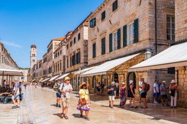 DUBROVNIK, CROATIA - 24 Haziran 2024: Tatilciler, ortaçağ duvarlarıyla çevrili ve Eski Liman manzaralı Hırvat kenti Dubrovnik 'te yaz tatilinin keyfini çıkarıyorlar