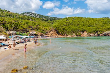 LOPUD, CROATIA - 28 Haziran 2024: Tatilciler, Adriyatik Denizi kıyısındaki Elaphiti adalarından biri olan Lopud 'da yaz tatili, kristal berrak sular ve kumlu Sunj plajlarının keyfini çıkarıyorlar.