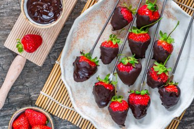Koyu çikolataya batırılmış taze çilekler.