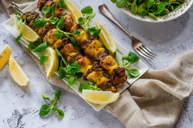 Izgara kuzu, sarı biber ve yeşil yaprak salatalı bebek patates şişleri.