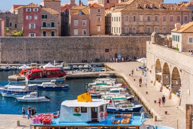 DUBROVNIK, CROATIA - 29 Haziran 2024: Seyahat gemileri ve yatları Eski Dubrovnik Limanı 'nda demirlidir. Liman ve Porporela Rıhtımı Eski Şehrin doğu yakasında yer almaktadır..