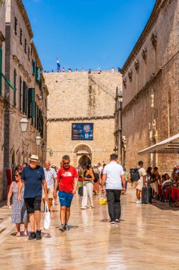 DUBROVNIK, CROATIA - 27 Haziran 2024: Tatilciler, ortaçağ duvarlarıyla çevrili ve Eski Liman manzaralı Hırvat kenti Dubrovnik 'te yaz tatilinin keyfini çıkarıyorlar