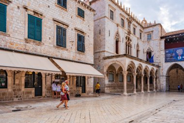 DUBROVNIK, CROATIA - 27 Haziran 2024: Tatilciler, ortaçağ duvarlarıyla çevrili ve Eski Liman manzaralı Hırvat kenti Dubrovnik 'te yaz tatilinin keyfini çıkarıyorlar