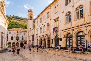 DUBROVNIK, CROATIA - 27 Haziran 2024: Tatilciler, ortaçağ duvarlarıyla çevrili ve Eski Liman manzaralı Hırvat kenti Dubrovnik 'te yaz tatilinin keyfini çıkarıyorlar