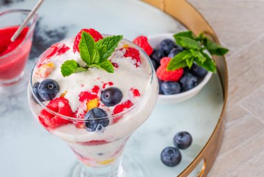 Taze meyve ve ahududu soslu vanilyalı dondurma.