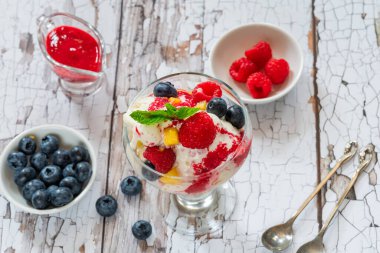 Taze meyve ve ahududu soslu vanilyalı dondurma.