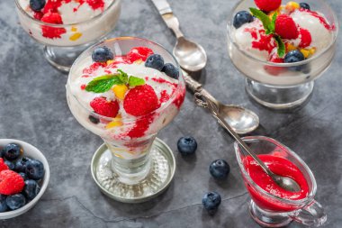 Taze meyve ve ahududu soslu vanilyalı dondurma.