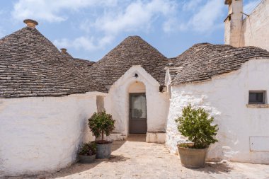 İtalya, Alberobello 'da konik çatıları olan ünlü tarihi kuru taş trulli evler..