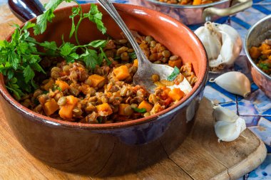 Kahverengi mercimek yahnisi, beyaz şarap, serrano jambonu ve füme paprika.