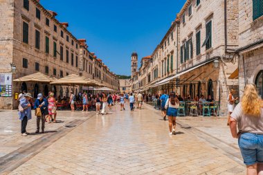 DUBROVNIK, CROATIA - 24 Haziran 2024: Tatilciler, ortaçağ duvarlarıyla çevrili ve Eski Liman manzaralı Hırvat kenti Dubrovnik 'te yaz tatilinin keyfini çıkarıyorlar
