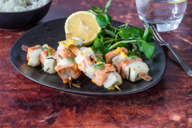 Mini somon ve halibut şişleri bal, biberiye ve limonla marine edilmiş.