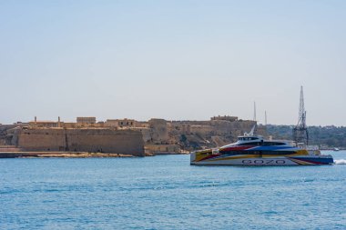 VALLETTA, MALTA - 30 Ağustos 2024: Yolcu feribotu insanları Valletta 'dan Neolitik Ggantija Tapınağı kalıntıları, kırsal yürüyüş yolları, plajlar ve tüplü dalış sahalarıyla bilinen Gozo adasına götürüyor.