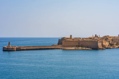 Ricasoli 'deki deniz feneri doğu dalgakıranı ve Valletta Grand Harbour, Malta' daki Ricasoli Kalesi..