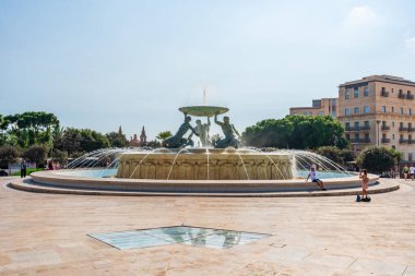 VALLETTA, MALTA - AUGUST 30 2024: The Tritons Fountain located in Floriana, consists of three bronze Tritons holding up a large basin. The fountain is one of Malta's most important Modernist landmarks clipart