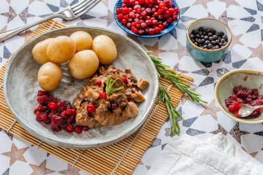 Geleneksel Norveç ren geyiği güveci, yaban mersini ve haşlanmış patates.