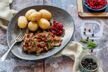 Geleneksel Norveç ren geyiği güveci, yaban mersini ve haşlanmış patates.