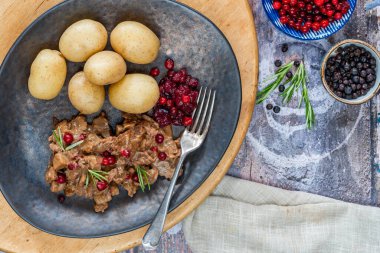 Geleneksel Norveç ren geyiği güveci, yaban mersini ve haşlanmış patates.