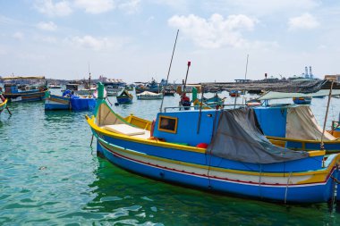 MARSAXLOKK, MALTA - SEPTEMBER 03, 2024: Geleneksel renkli balıkçı tekneleri, Malta 'nın küçük bir balıkçı kasabası olan Marsaxlokk limanına demirlemişti..