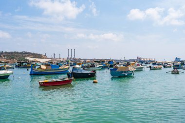 MARSAXLOKK, MALTA - SEPTEMBER 03, 2024: Geleneksel renkli balıkçı tekneleri, Malta 'nın küçük bir balıkçı kasabası olan Marsaxlokk limanına demirlemişti..