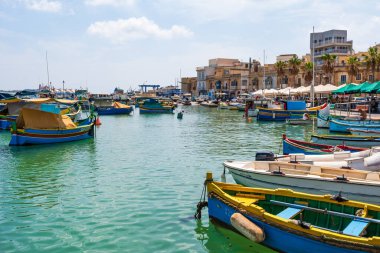 MARSAXLOKK, MALTA - SEPTEMBER 03, 2024: Geleneksel renkli balıkçı tekneleri, Malta 'nın küçük bir balıkçı kasabası olan Marsaxlokk limanına demirlemişti..