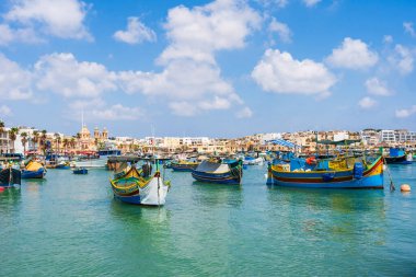 MARSAXLOKK, MALTA - SEPTEMBER 03, 2024: Geleneksel renkli balıkçı tekneleri, Malta 'nın küçük bir balıkçı kasabası olan Marsaxlokk limanına demirlemişti..