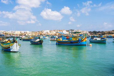 MARSAXLOKK, MALTA - SEPTEMBER 03, 2024: Geleneksel renkli balıkçı tekneleri, Malta 'nın küçük bir balıkçı kasabası olan Marsaxlokk limanına demirlemişti..
