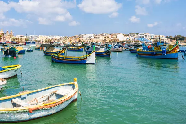 MARSAXLOKK, MALTA - SEPTEMBER 03, 2024: Geleneksel renkli balıkçı tekneleri, Malta 'nın küçük bir balıkçı kasabası olan Marsaxlokk limanına demirlemişti..