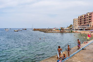 MARSALFORN, GoZO, MALTA - Eylül 01, 2024: Resimli bir Marsalforn Körfezi Gozo 'nun en popüler plajlarından biridir ve su sporları ve dalgıçlar için bir cennettir.. 