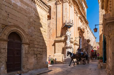 MDINA, MALTA - SEPTEMBER 02, 2024: Ziyaretçiler at arabalarıyla Mdina 'yı keşfediyorlar. Mdina bir zamanlar Malta 'nın başkentiydi ve şimdi adanın başlıca turistik merkezlerinden biri..