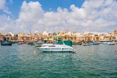 MARSAXLOKK, MALTA - SEPTEMBER 03, 2024: Geleneksel renkli balıkçı tekneleri, Malta 'nın küçük bir balıkçı kasabası olan Marsaxlokk limanına demirlemişti..