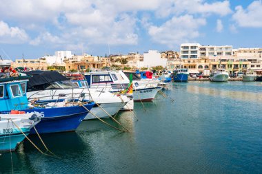 MARSAXLOKK, MALTA - SEPTEMBER 03, 2024: Geleneksel renkli balıkçı tekneleri, Malta 'nın küçük bir balıkçı kasabası olan Marsaxlokk limanına demirlemişti..