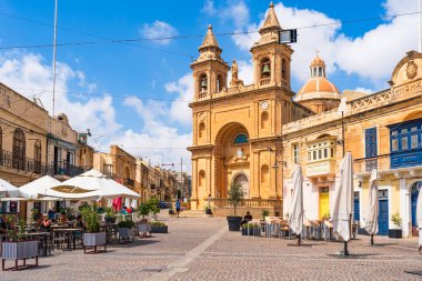 MARSAXLOKK, MALTA - SEPTEMBER 03, 2024: Marsaxlokk, Malta kıyılarında küçük, pitoresk bir balıkçı köyüdür. Turistler arasında görüşleri, balıkçılık ve tarihi açısından popülerdir..