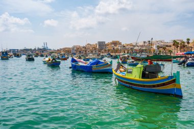 MARSAXLOKK, MALTA - SEPTEMBER 03, 2024: Geleneksel renkli balıkçı tekneleri, Malta 'nın küçük bir balıkçı kasabası olan Marsaxlokk limanına demirlemişti..